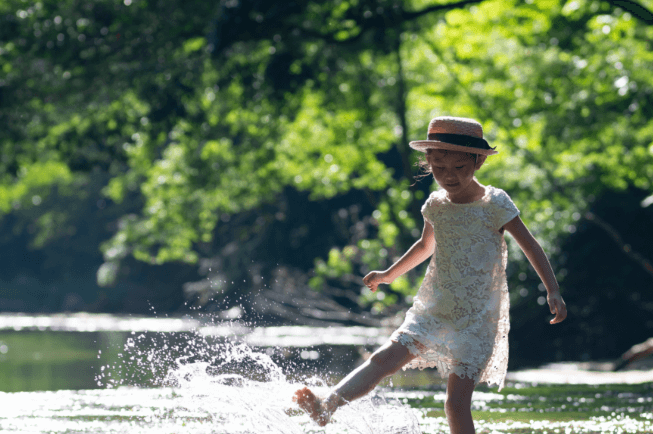 テントサイト 川で遊ぶ子供と浮き輪の画像
